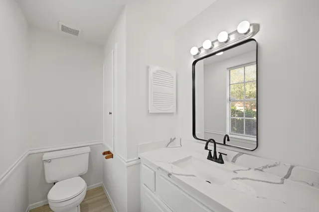 a bathroom with a toilet sink and mirror