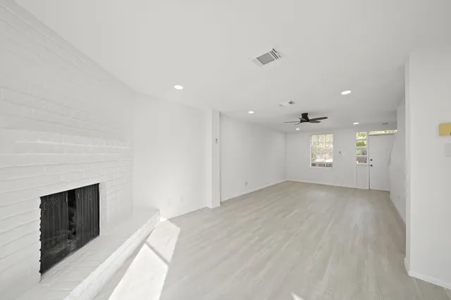 a view of an empty room with a fireplace and a window