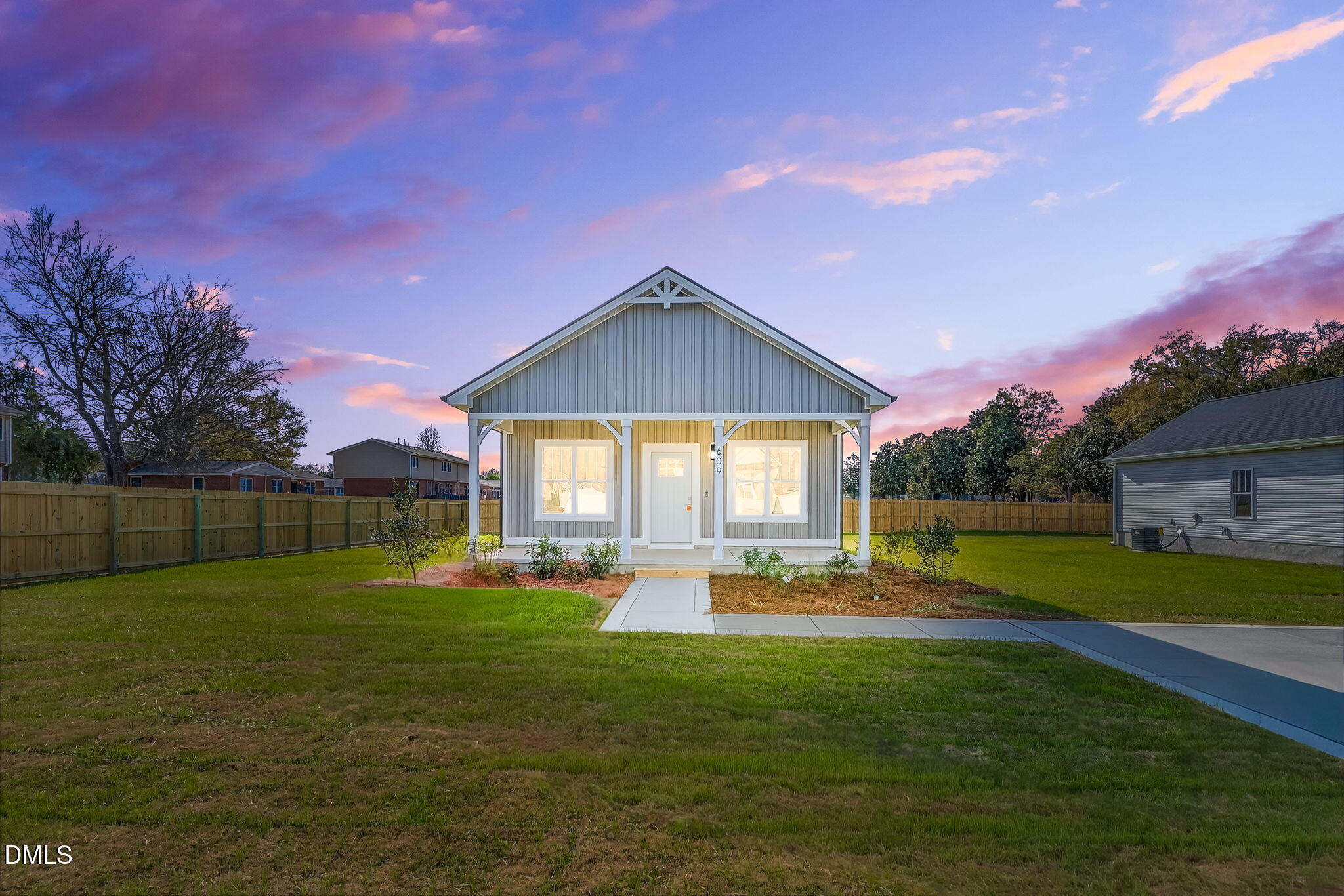 a view of a house with a big yard and a large tree
