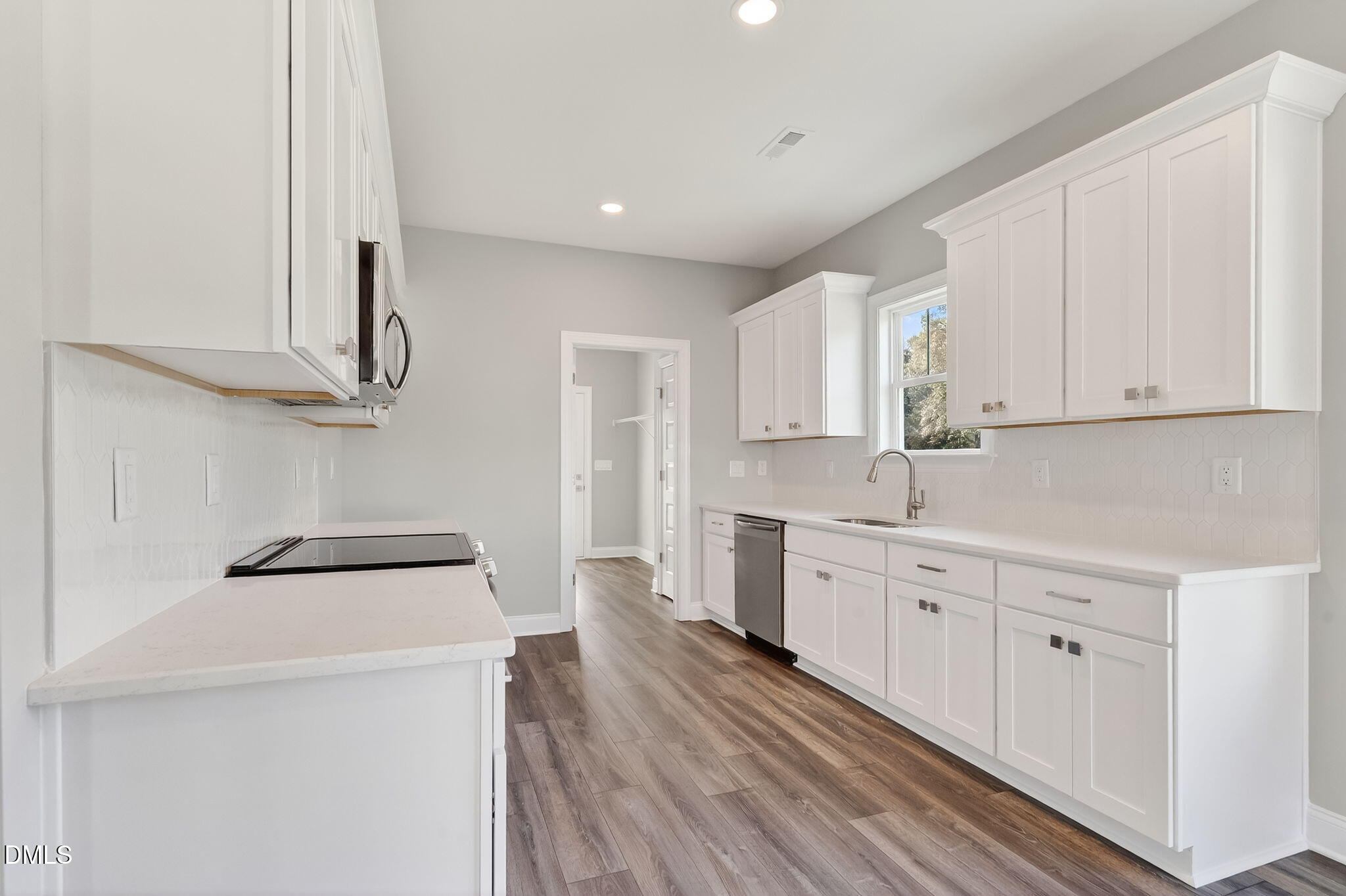 609 West Godwin Street Dunn, NC 28334 - Photo 12 of 38 a kitchen with cabinets a sink and wooden floor