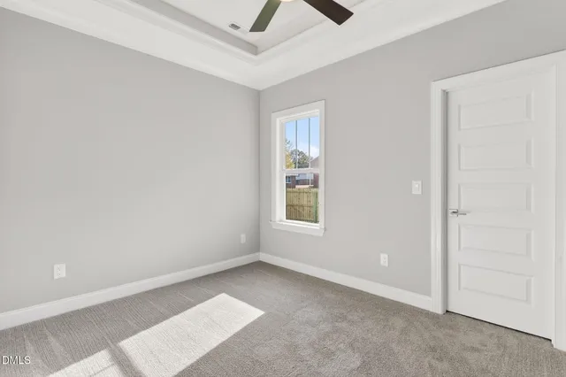 an empty room with a ceiling fan and window