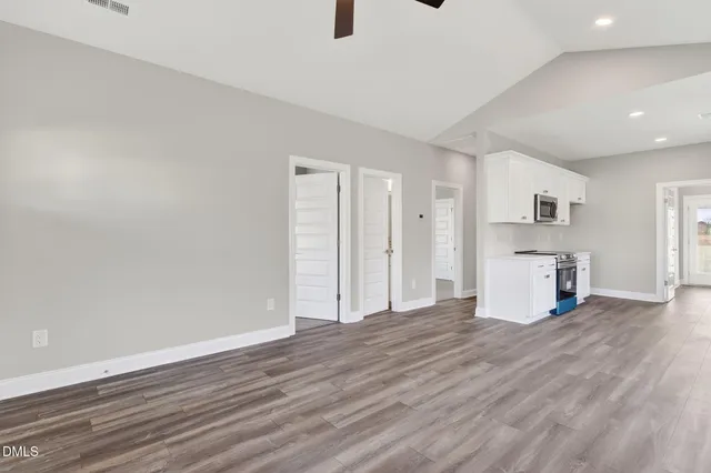 a view of empty room with wooden floor and window