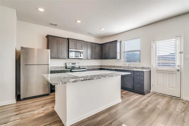 a view of kitchen with refrigerator and window