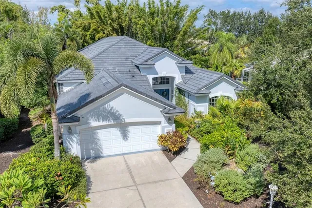 a aerial view of a house with a yard and large trees