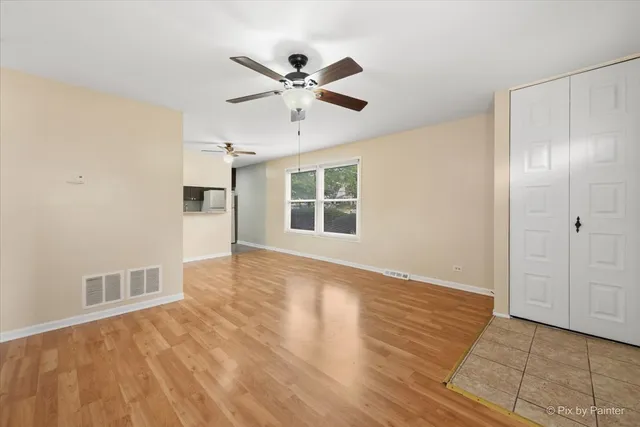a view of empty room with wooden floor and window