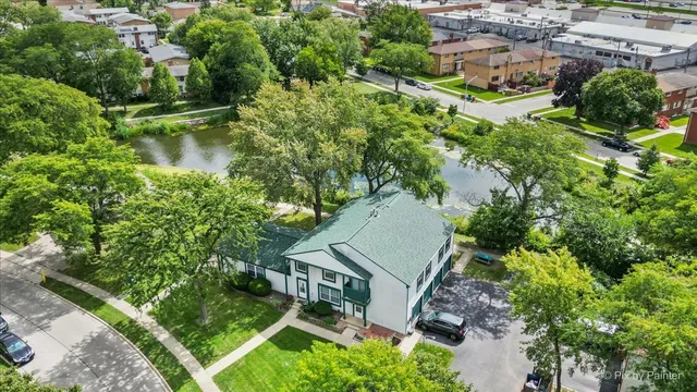 an aerial view of residential house with outdoor space and trees all around