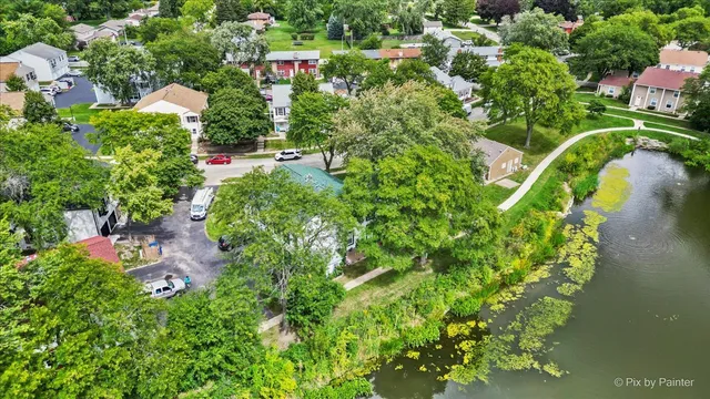 an aerial view of residential house with outdoor space and trees all around