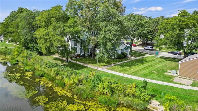 an aerial view of residential houses with outdoor space and trees