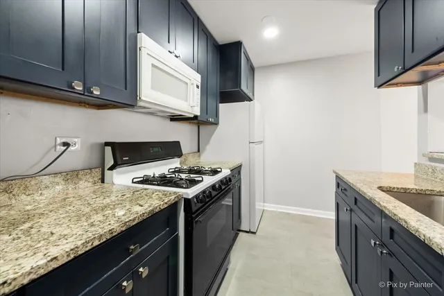 a kitchen with stainless steel appliances granite countertop a stove a sink and a microwave