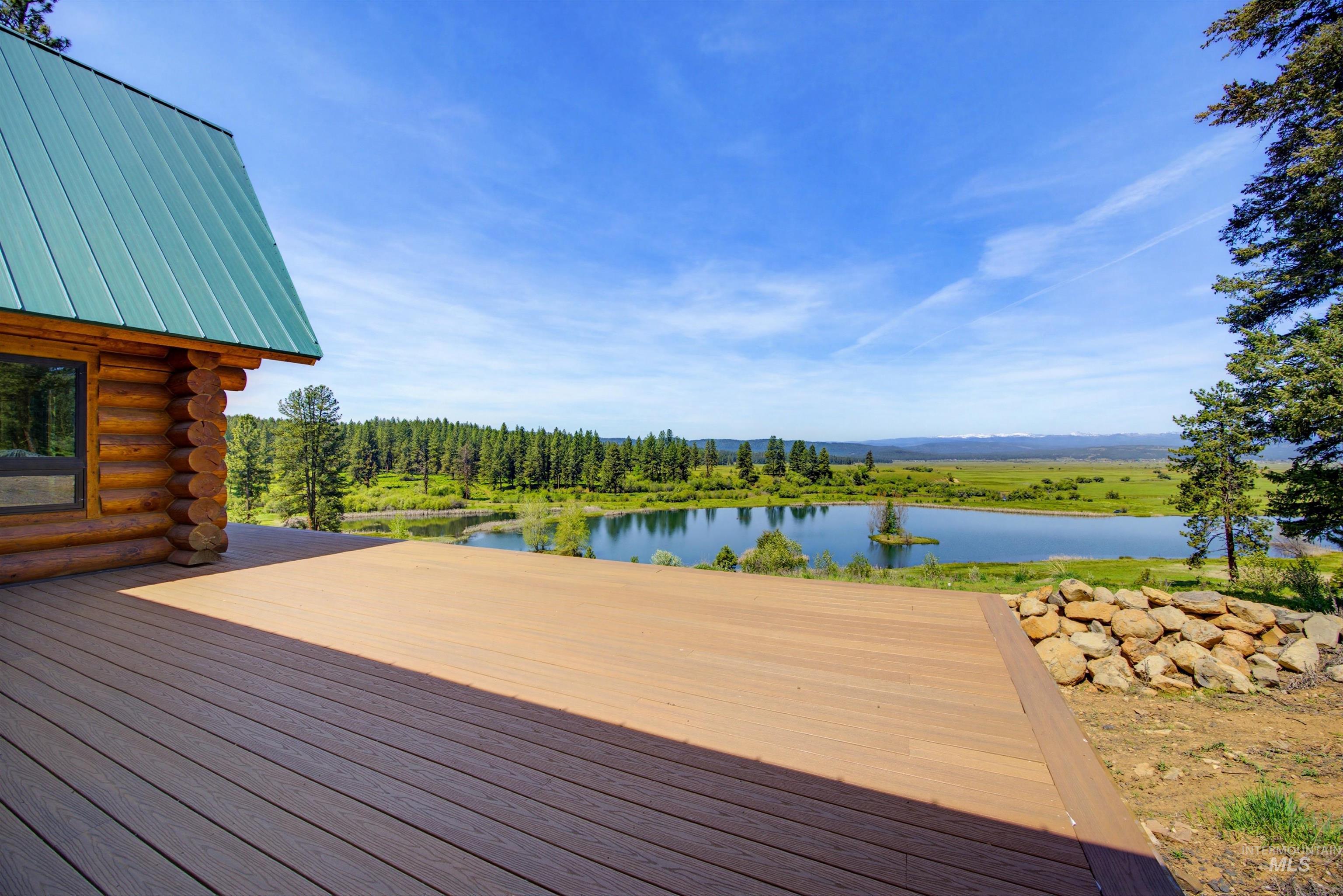 3322 Big Creek Road New Meadows, ID 83654 - Photo 7 of 50 Spacious outdoor deck with composite decking and a log cabin exterior, featuring a green metal roof