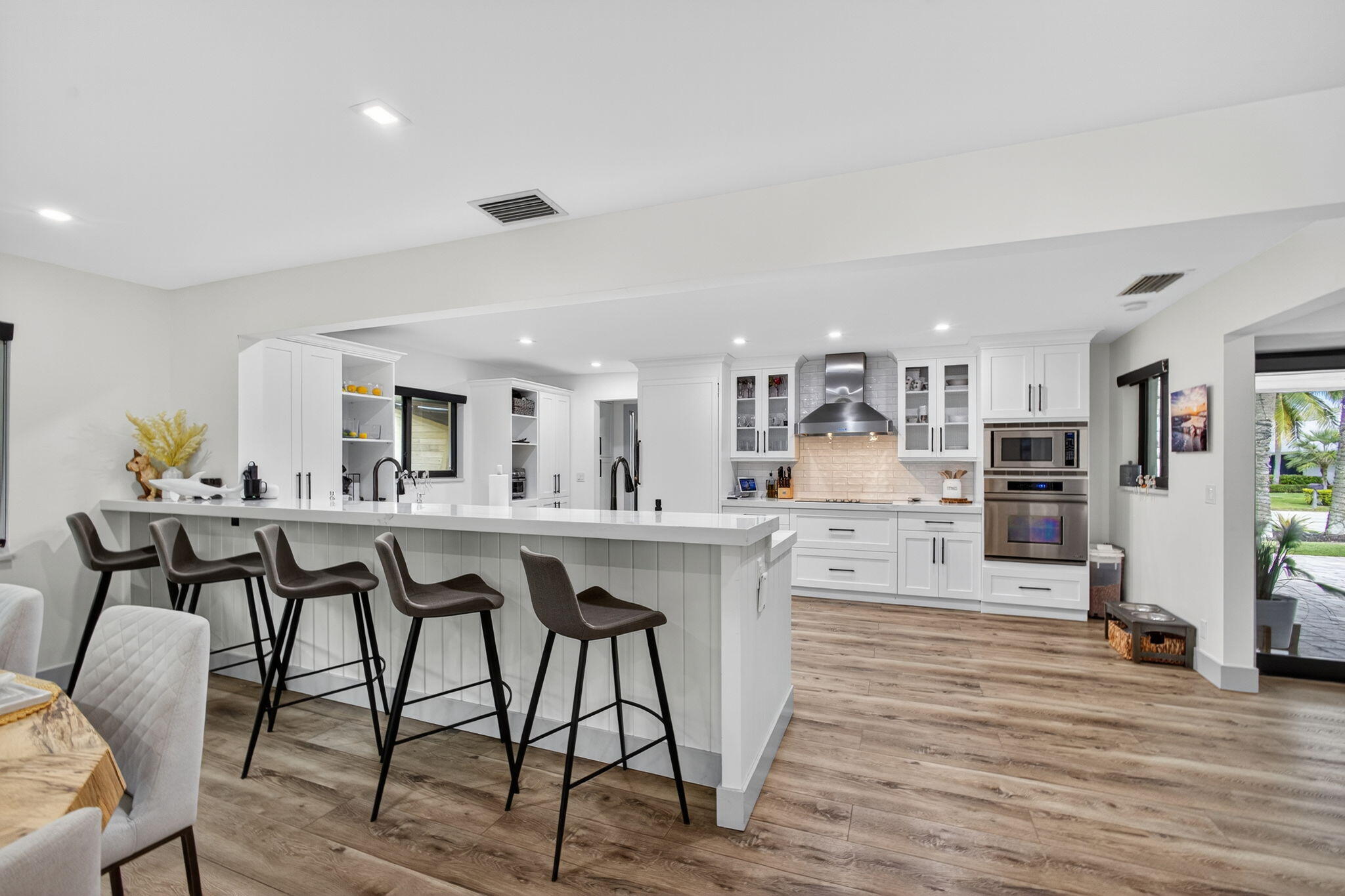12 Leeward Circle Tequesta, FL 33469 - Photo 19 of 61 a kitchen with stainless steel appliances granite countertop a table chairs stove and white cabinets