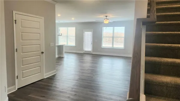 a view of an empty room with a window and wooden floor