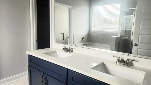 a bathroom with double sink and a mirror