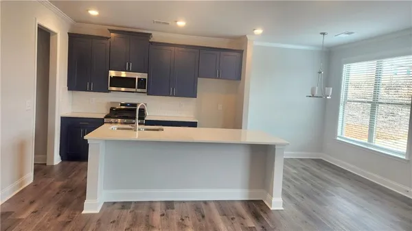 a kitchen with kitchen island a sink stainless steel appliances and cabinets