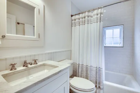 a bathroom with a granite countertop sink toilet and shower