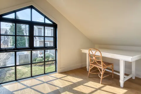 a view of a room with wooden floor and windows