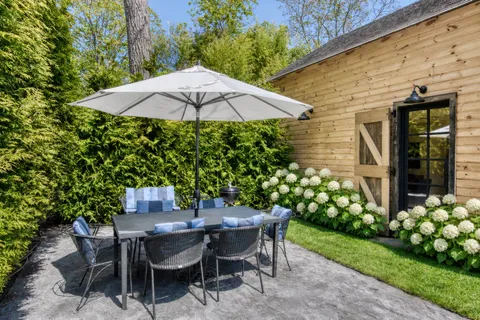 a backyard of a house with table and chairs