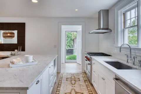 a kitchen that has a sink a stove and a table