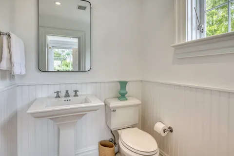 a bathroom with a toilet a sink and mirror