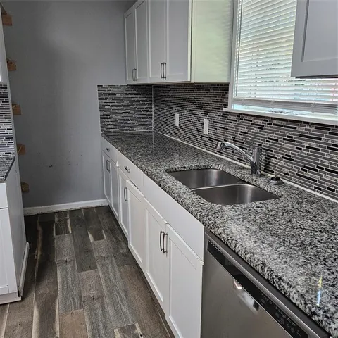 a kitchen with granite countertop a sink and a stove