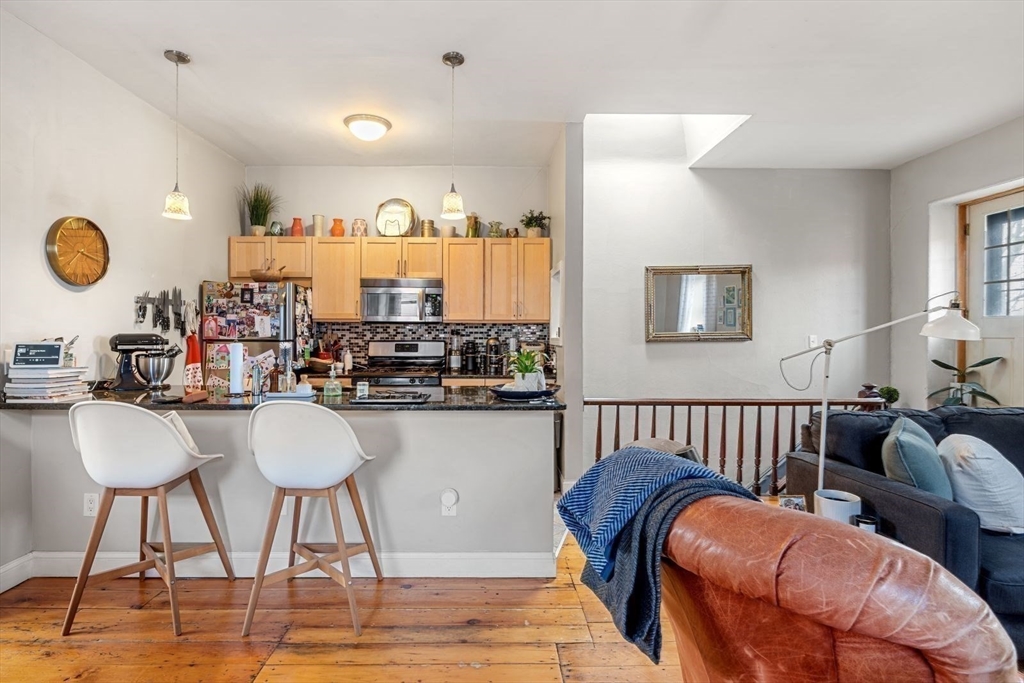 124 F Street Boston, MA 02127 - Photo 16 of 28 a kitchen with stainless steel appliances kitchen island granite countertop a dining table chairs and a sink