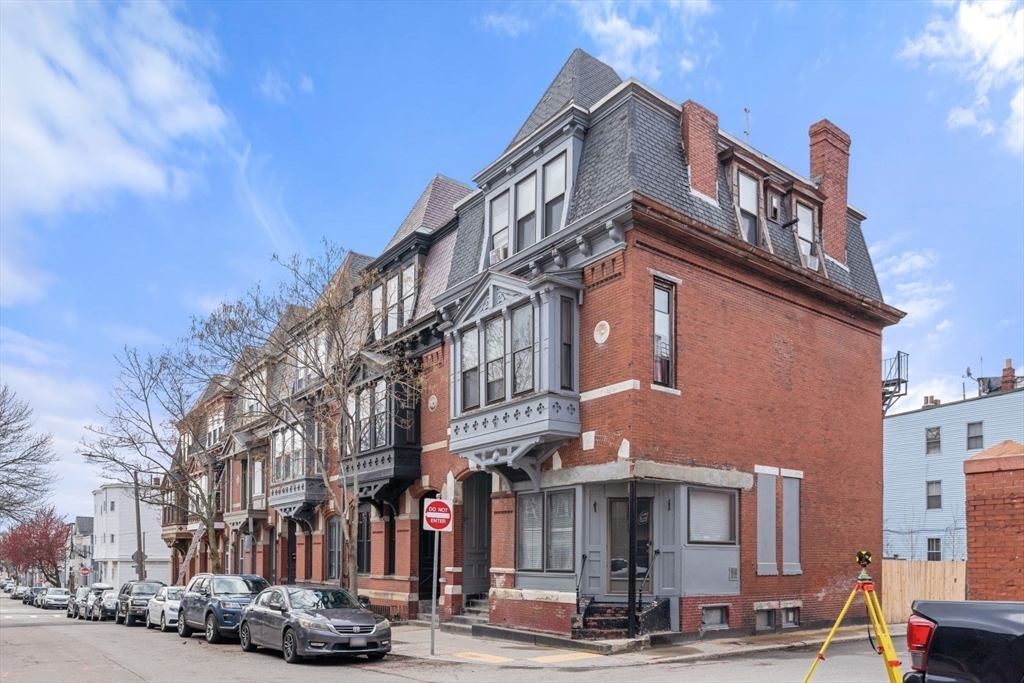 124 F Street Boston, MA 02127 - Photo 2 of 28 a front view of a building with lot of cars and trees