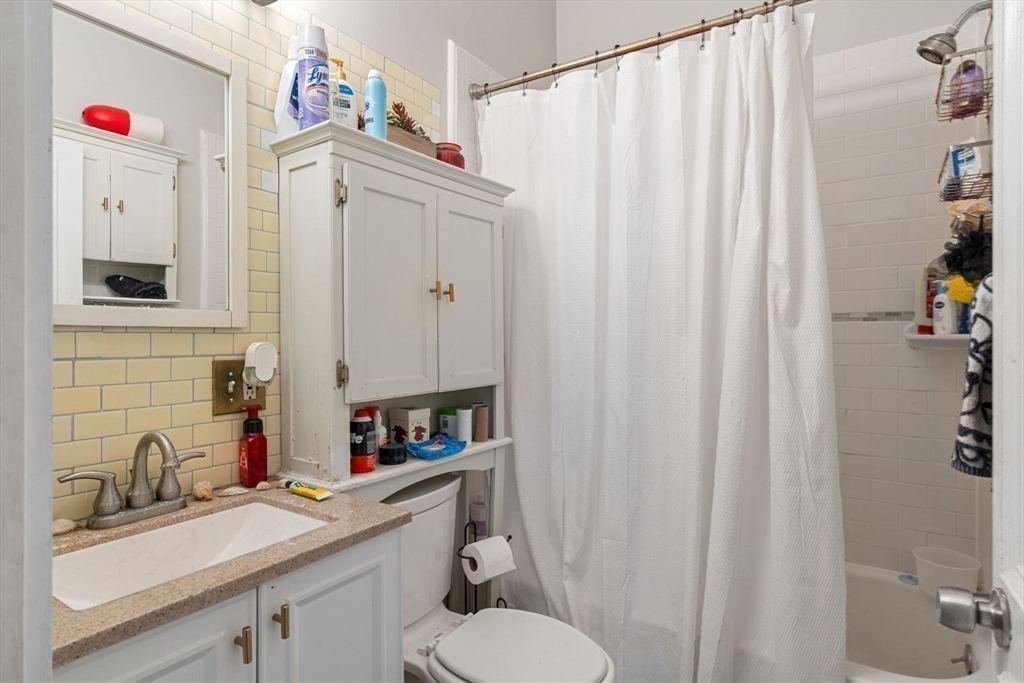 124 F Street Boston, MA 02127 - Photo 21 of 28 a bathroom with a sink vanity mirror and toilet
