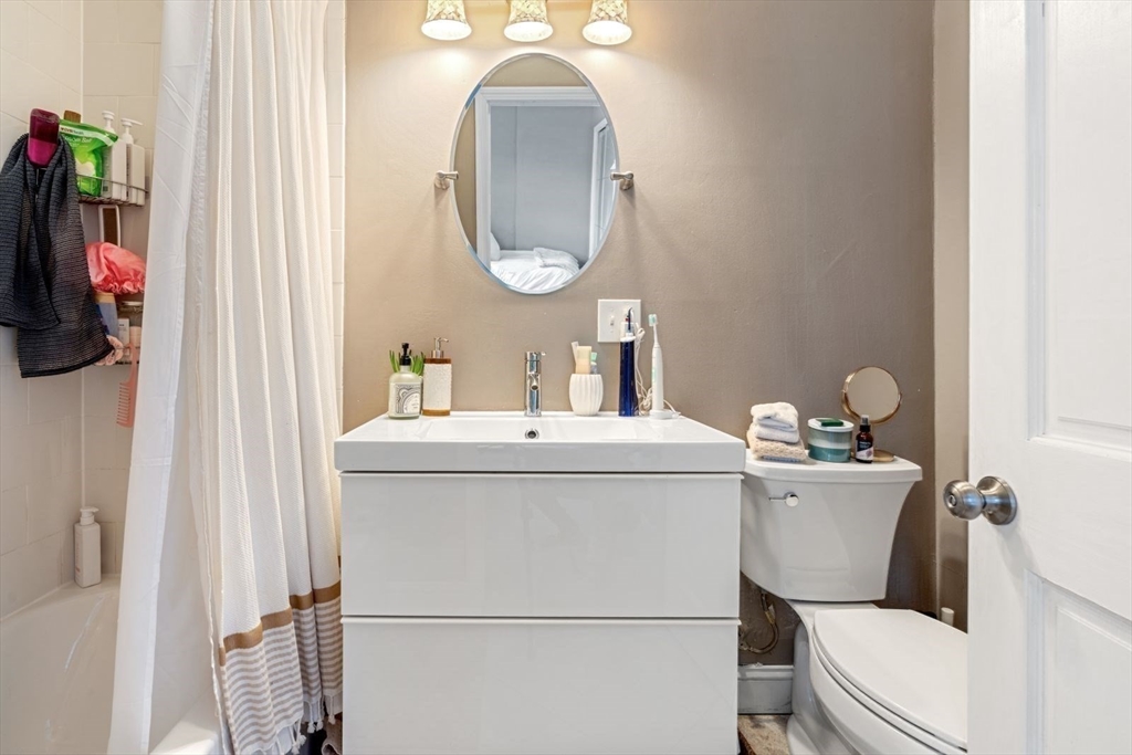 124 F Street Boston, MA 02127 - Photo 22 of 28 a bathroom with a sink mirror vanity and toilet