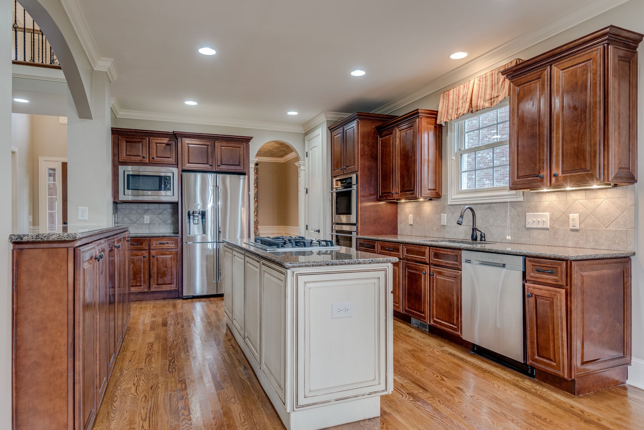 281 King Arthur Circle Franklin, TN 37067 - Photo 19 of 47 a kitchen with stainless steel appliances granite countertop hardwood floor sink stove and wooden cabinets