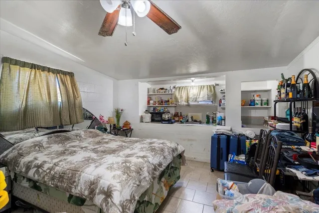 a bedroom with a bed gym equipment and a large window
