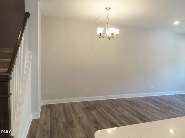 a view of a room with wooden floor and chandelier