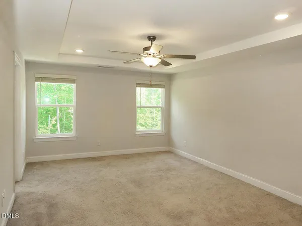 an empty room with a window and a ceiling fan