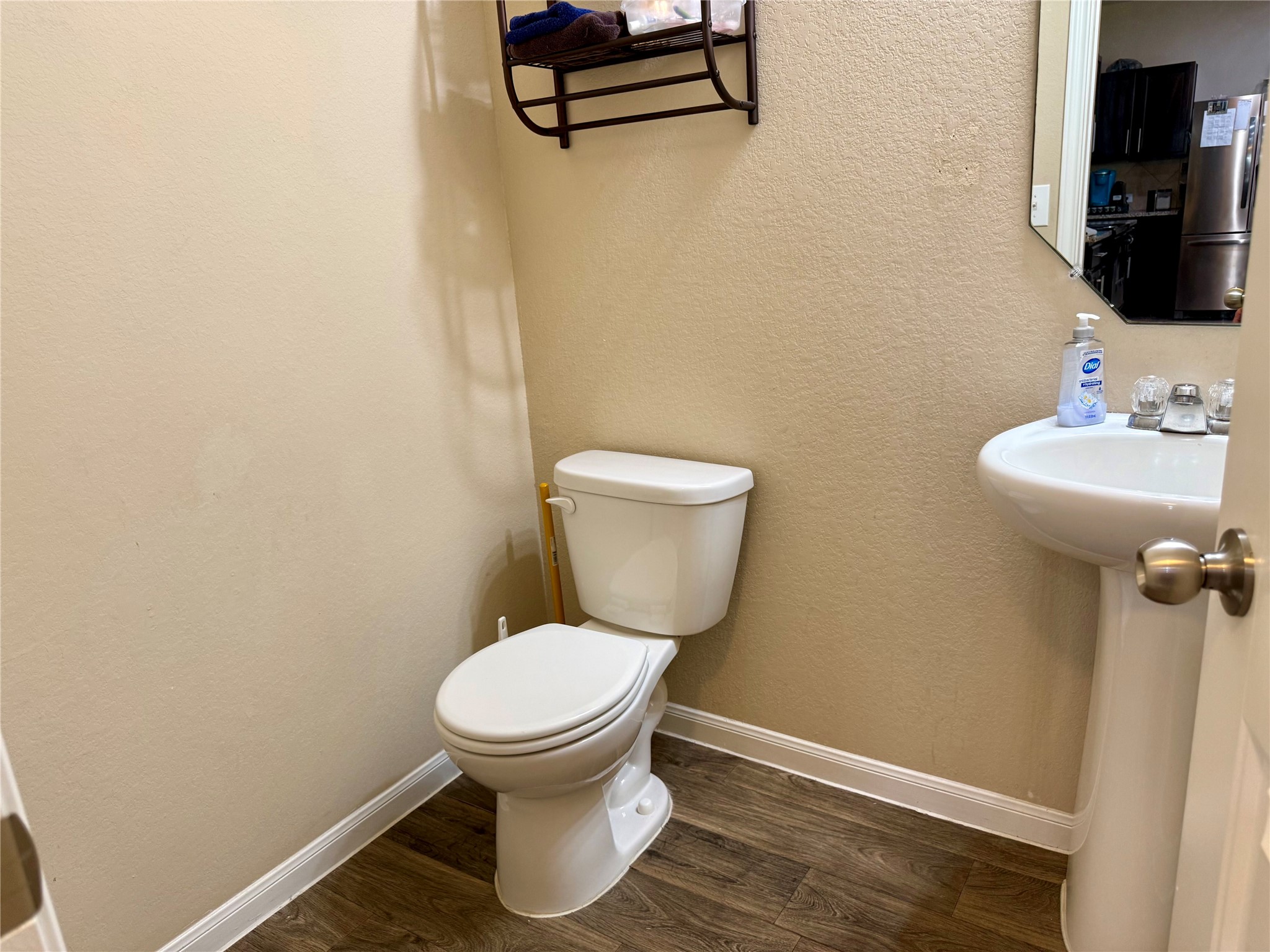 11700 Andesite Road Manor, TX 78653 - Photo 12 of 32 A well-appointed half bath features wood flooring and a pedestal sink.