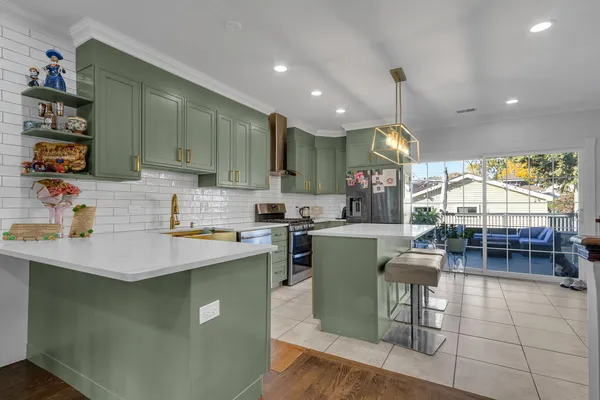a kitchen with kitchen island granite countertop a sink a counter top space appliances and cabinets