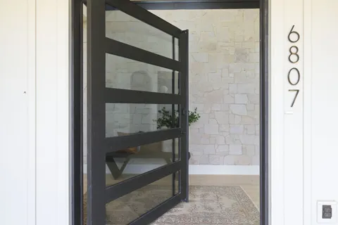 a bathroom with a glass shower door and a window