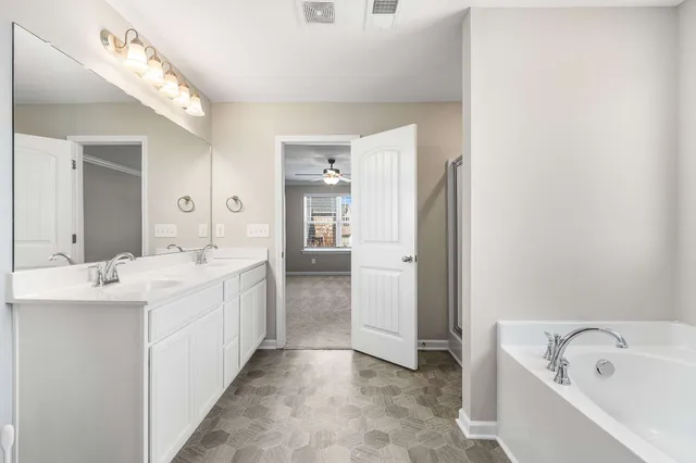 a large bathroom with a double vanity sink a mirror and a bathtub