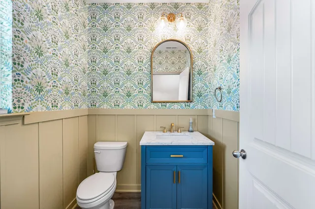 a bathroom with a toilet sink and mirror