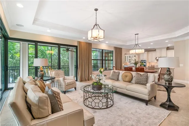 a living room with furniture chandelier and a large window