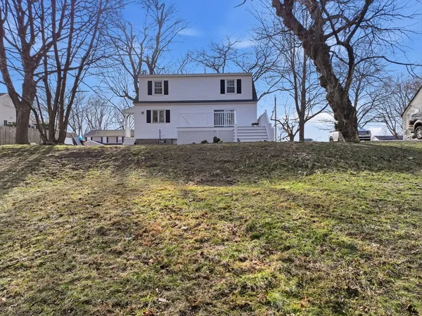 a view of a house with a yard and wooden fence
