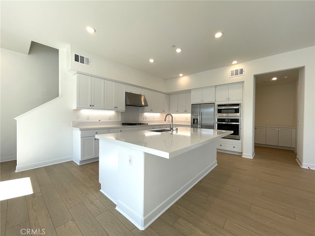 141 Baluster Irvine, CA 92618 - Photo 13 of 40 a large kitchen with kitchen island a sink dishwasher stove and refrigerator