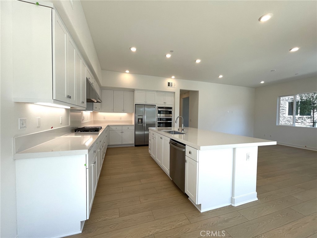 141 Baluster Irvine, CA 92618 - Photo 14 of 40 a large kitchen with stainless steel appliances kitchen island a large counter top and a stove top oven