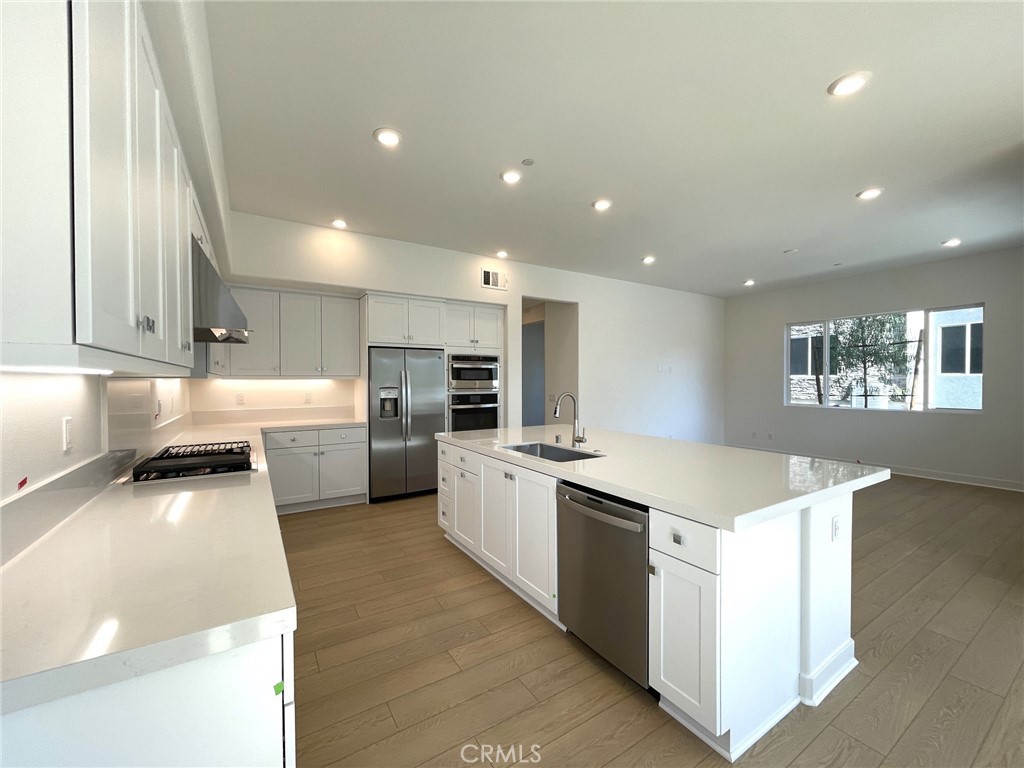 141 Baluster Irvine, CA 92618 - Photo 15 of 40 a large kitchen with stainless steel appliances lots of counter space and wooden floor