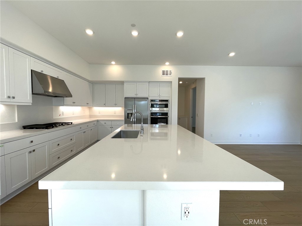 141 Baluster Irvine, CA 92618 - Photo 16 of 40 a large kitchen with kitchen island a stove a sink a refrigerator and a microwave