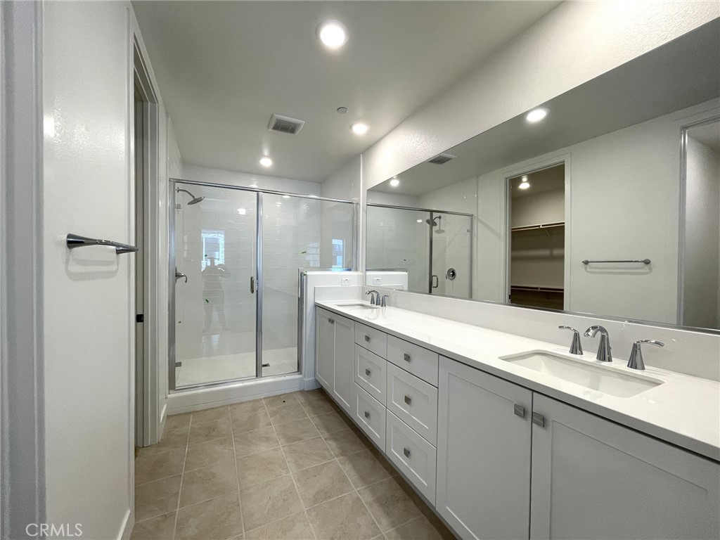 141 Baluster Irvine, CA 92618 - Photo 25 of 40 a bathroom with a shower sink double and mirror