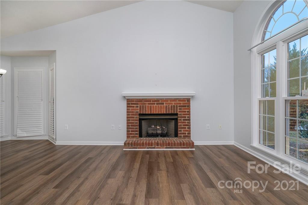 2432 River Chase Drive Monroe, NC 28110 - Photo 3 of 18 an empty room with wooden floor fireplace and windows