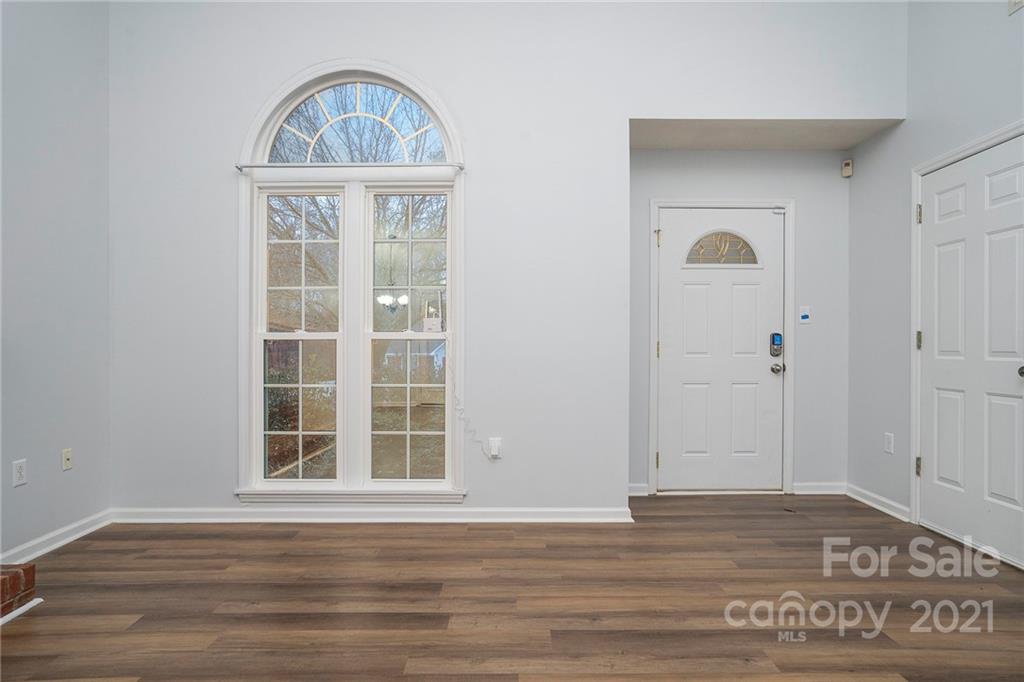 2432 River Chase Drive Monroe, NC 28110 - Photo 9 of 18 an empty room with wooden floor cabinet and windows