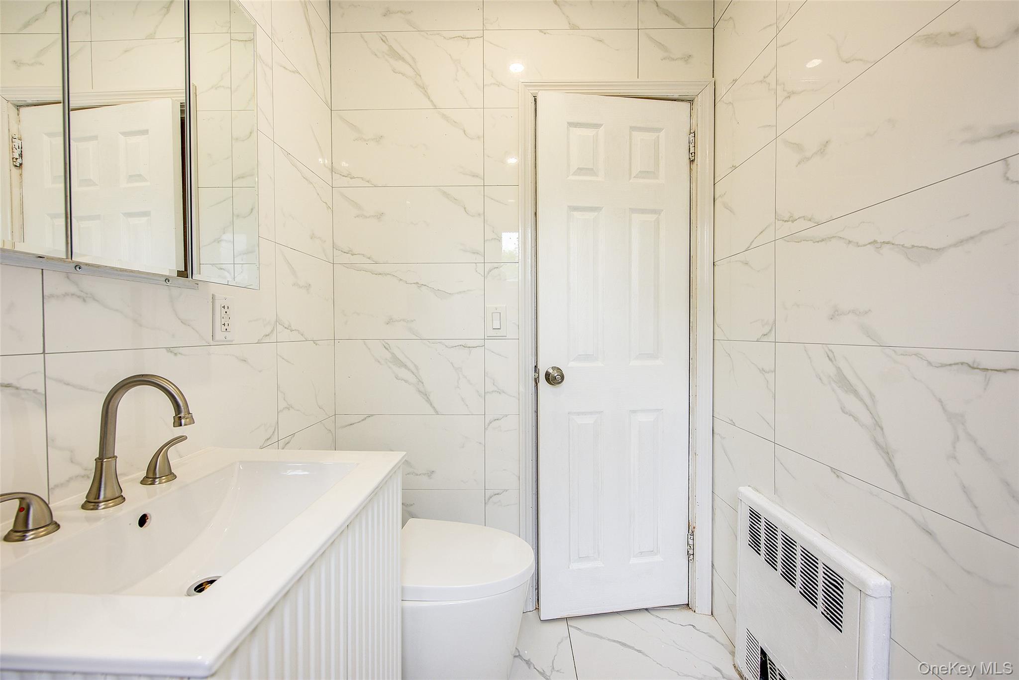 164-38 76th Road Queens, NY 11366 - Photo 19 of 44 a bathroom with a sink and toilet