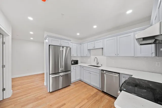 a kitchen with white cabinets and stainless steel appliances