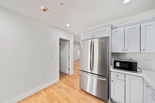 a white refrigerator freezer and a stove sitting inside of a kitchen