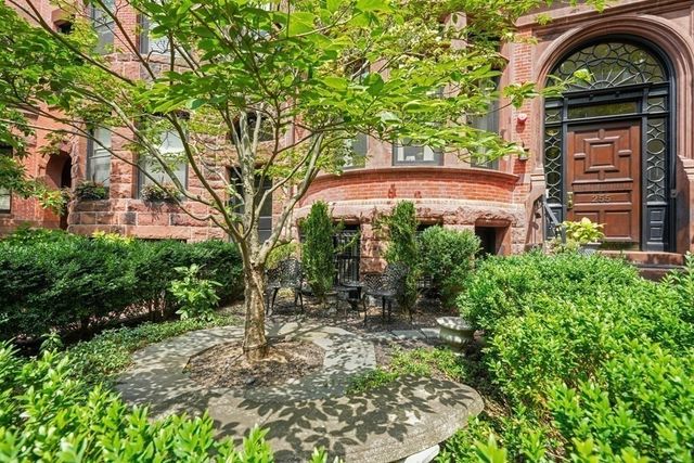 a view of a brick house with a small yard
